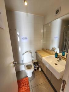 a bathroom with a toilet and a sink and a mirror at Playa Huayquique, primera linea in Iquique +18 photos