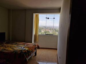 - une chambre avec un lit et une grande fenêtre dans l'établissement Departamento con Hermosa Vista, à Yanahuara