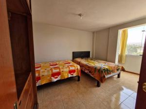 - une chambre avec 2 lits et une fenêtre dans l'établissement Departamento con Hermosa Vista, à Yanahuara