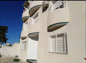 een wit gebouw met ramen aan de zijkant bij Duplex El mansoura A1 in Kelibia