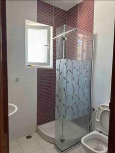 een badkamer met een douche en een toilet bij Duplex El mansoura A1 in Kelibia