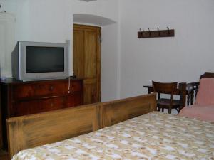 ein Schlafzimmer mit einem Bett und einem TV auf einer Kommode in der Unterkunft Wohnung in Campregheri mit Terrasse in Campregheri