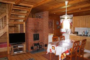 uma cozinha e sala de jantar com uma mesa e uma lareira em Ferienhaus in Kouvola mit Terrasse und Grill em Kouvola