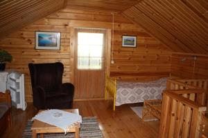 una camera con un letto in una baita di tronchi di Ferienhaus in Kouvola mit Terrasse und Grill a Kouvola