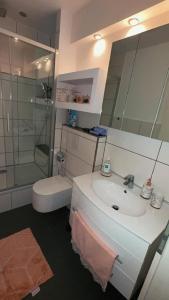 a bathroom with a sink and a shower and a toilet at New York by D&J Apartments Altenessen Nord in Essen