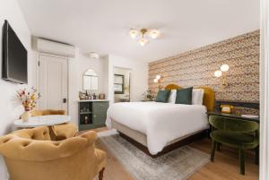um quarto com uma cama branca e uma parede de tijolos em Petit Soleil - Bed, Breakfast and Bar em San Luis Obispo