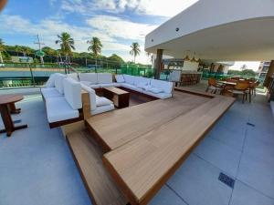 um pátio com sofás e mesas brancas e uma piscina em Flat Sol do Makia - Studio com vista para piscina em Ipojuca