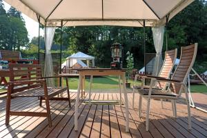 a table and chairs under an umbrella on a deck at THE FARM Resort Japan in Katori