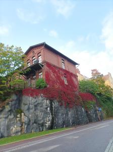 ein Gebäude auf einer Felswand mit einem Haus in der Unterkunft Orchid&Sakura studios Kamppi in Helsinki + 8 Fotos