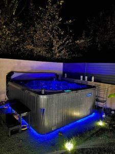 a hot tub with blue lights in a backyard at night at Maison familiale avec SPA in Fontenay-Trésigny