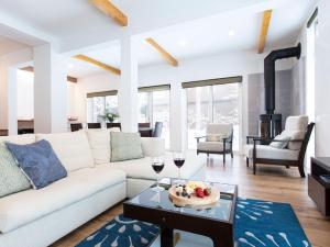 a living room with a white couch and glasses of wine at Ajisai Chalet in Niseko