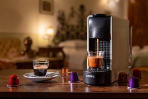 eine Kaffeemaschine auf einem Tisch mit einem Glas Kaffee in der Unterkunft Sant'Ivo Apartments in Rom