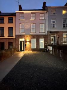 an empty parking lot in front of a building at Westland Suites - Stylish, Modern, Elegant, Central Apartments in Londonderry County Borough