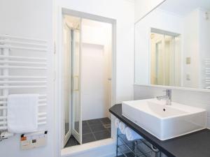 a white bathroom with a sink and a shower at Ajisai Chalet in Niseko