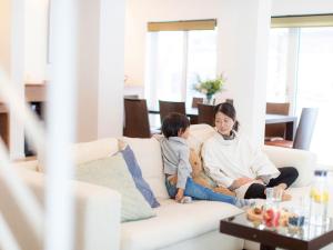 Eine Frau und ein Kind auf einer Couch in der Unterkunft Ajisai Chalet in Niseko