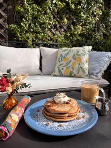 einen Teller Pfannkuchen auf einem Tisch mit einer Couch in der Unterkunft Petit Soleil - Bed, Breakfast and Bar in San Luis Obispo