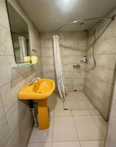 a bathroom with a yellow sink and a shower at The View Apartments in Yerevan