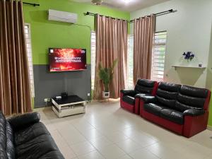 sala de estar con sofá y TV de pantalla plana en Homestay Ustaz Free Internet WiFi Android TV, en Pekan