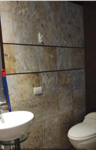 een badkamer met een wit toilet en een wastafel bij Casa Punta Hermosa Piscina Terraza in Punta Hermosa