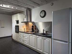 eine Küche mit weißen Schränken und einer Uhr an der Wand in der Unterkunft Gîte Sigloy, 3 pièces, 5 personnes - FR-1-590-125 in Sigloy