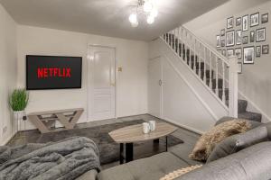 un soggiorno con divano e TV di Large cosy house w/driveway 7pax a Radcliffe