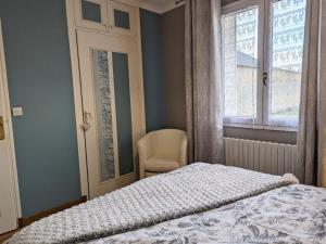 una camera da letto con un letto, una sedia e una finestra di Gîte chaleureux en pleine campagne avec cour privée, vélos, ping-pong et à 1h de Paris - FR-1-590-22 a Folleville