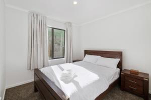 - une chambre avec un grand lit et une fenêtre dans l'établissement The Lookout, à Rotorua