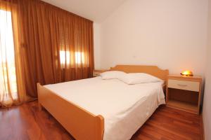 sypialnia z dużym łóżkiem i oknem w obiekcie Apartments by the sea Pasman - 8215 w mieście Pašman