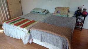 a bedroom with a bed with a quilt on it at CASA JARDIN in Sonsonate