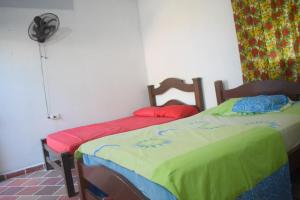 1 Schlafzimmer mit 2 Einzelbetten und einem Ventilator in der Unterkunft Shaddai restaurante y hospedaje in Puerto Triunfo