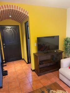sala de estar con TV de pantalla plana junto a una puerta en Acogedora casa con firepit, en San Juan del Obispo