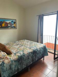a bedroom with a bed next to a window at Acogedora casa con firepit in San Juan Obispo +33 photos