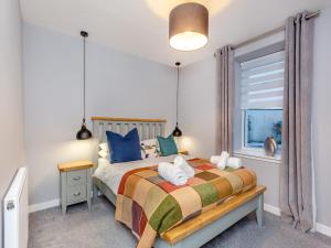 a bedroom with a bed and a window at Vectis Cottage in Inverness
