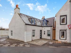 una grande casa bianca con tetto di Vectis Cottage a Inverness