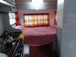 a small room with a bed in a tiny house at Tiny House Ventania in Sierra de la Ventana