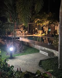 - une piscine la nuit avec une lumière à côté dans l'établissement B&B Forest Hill Khao Yai, à Ban Noen Hom