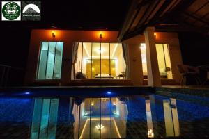 a swimming pool in front of a house at night at Khaosok legend in Khao Sok National Park
