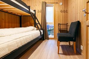 um quarto com um beliche e uma cadeira em Mountain View Cabin em Pettvik