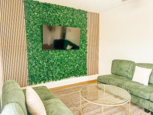 ein Wohnzimmer mit einem Sofa und einer grünen Wand in der Unterkunft Private Rooftop Oasis in North Park in San Diego