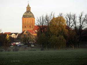 duży budynek z wieżą zegarową na polu w obiekcie Bungalow mit Kamin in Ribnitz-Damgarten w mieście Ribnitz-Damgarten