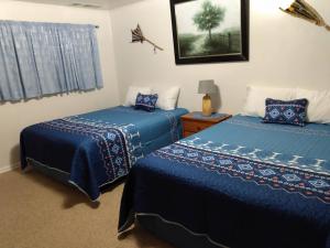 two beds in a room with blue comforters at Mokee Motel in Bluff
