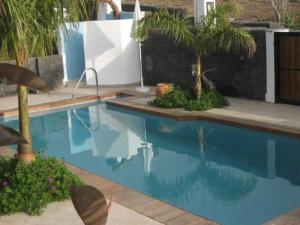 una piscina en un patio con palmeras en Ferienhaus aus zwei Wohneinheiten bestehend mit beheiztem Pool und Terrasse - b44101, en Playa Blanca