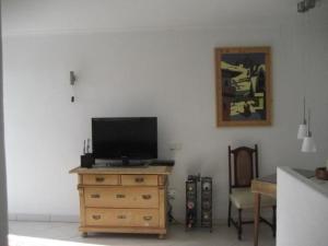 una sala de estar con TV en un tocador de madera en Ferienhaus aus zwei Wohneinheiten bestehend mit beheiztem Pool und Terrasse - b44101, en Playa Blanca