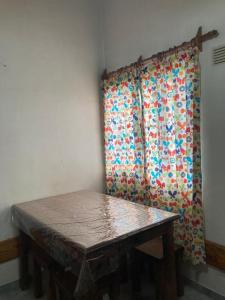 a table in front of a window with a curtain at Casa Nelly 2 in Playa Unión