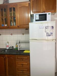 a white refrigerator with a microwave on top of it at Casa Nelly 2 in Playa Unión