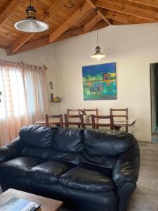a black leather couch in a living room with a table at Casa Nelly 2 in Playa Unión