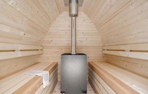a small wooden sauna with a stove in it at Amazing Home In Ebeltoft With Kitchen in Ebeltoft