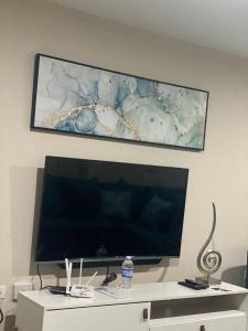 uma grande televisão de ecrã plano pendurada numa parede em Finest Accommodation Bay Front Villa G9 em Portmore