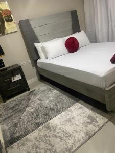 um quarto com uma cama com uma almofada vermelha em Finest Accommodation Bay Front Villa G9 em Portmore