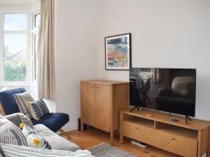 salon z kanapą i telewizorem w obiekcie Sea Breeze Apartment w mieście Goring by Sea